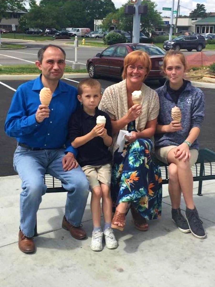 This woman offered to take a picture of a family that seemed very happy that they went for ice cream together